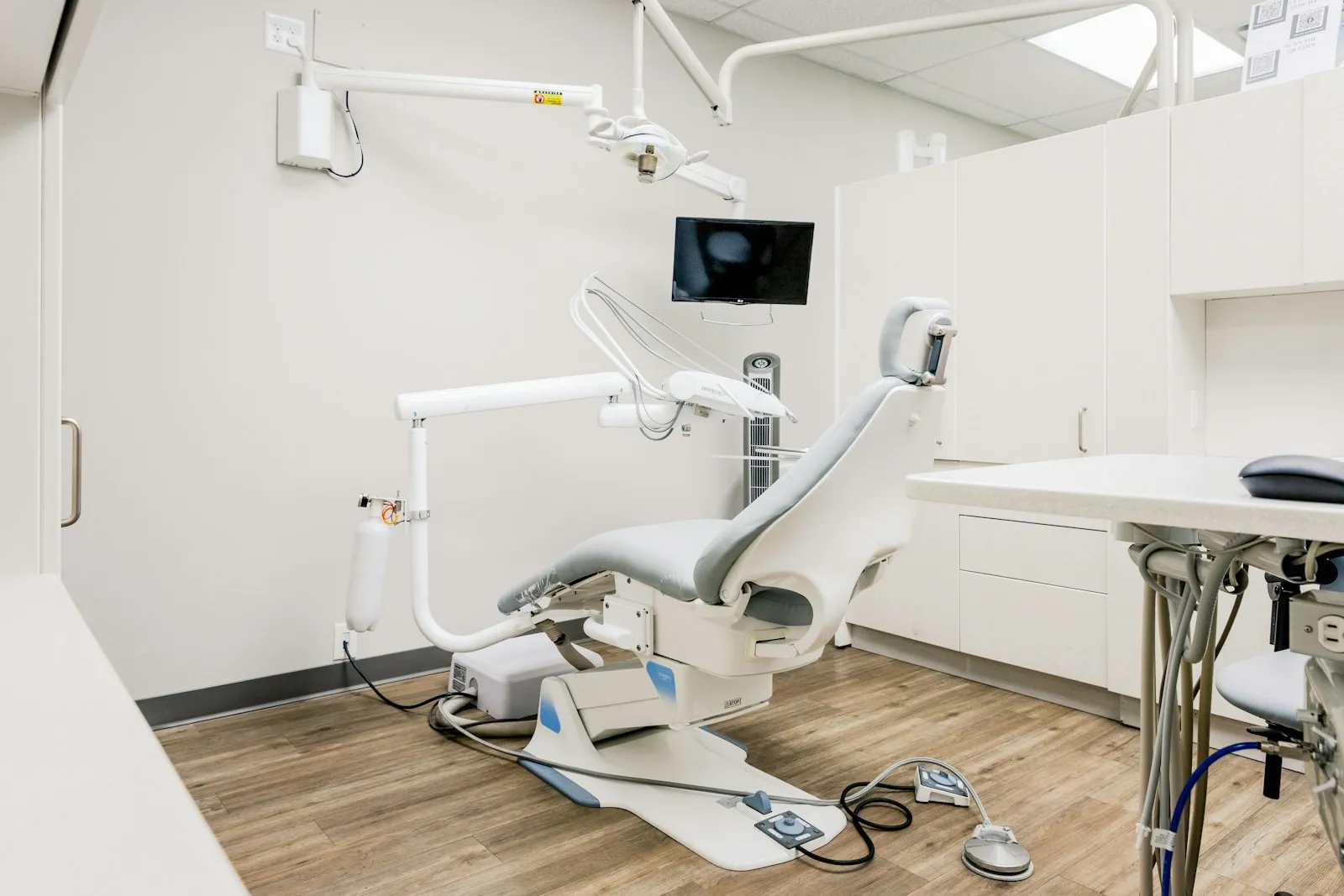 A clean, modern dental treatment room with a reclining chair.